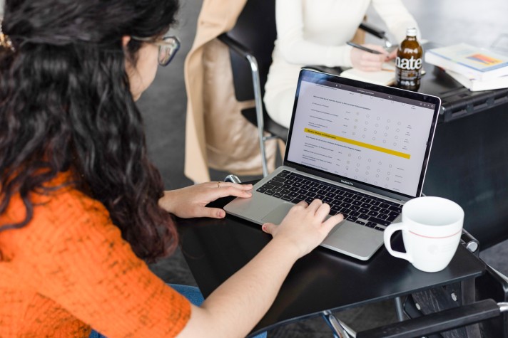 Eine Studentin sitzt am Laptop und füllt eine Befragung aus. 