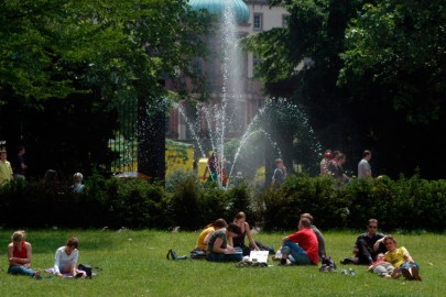 Studierende sitzen auf einr Wiese im Herrngarten. Im Hintergrund ist ein Springbrunnen zu sehen.