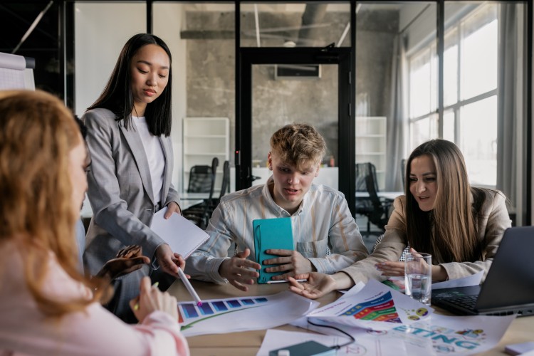 Studierende sitzen am Tisch und arbeiten zusammen